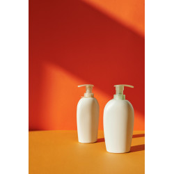 Two White Pump Bottles on Yellow Surface