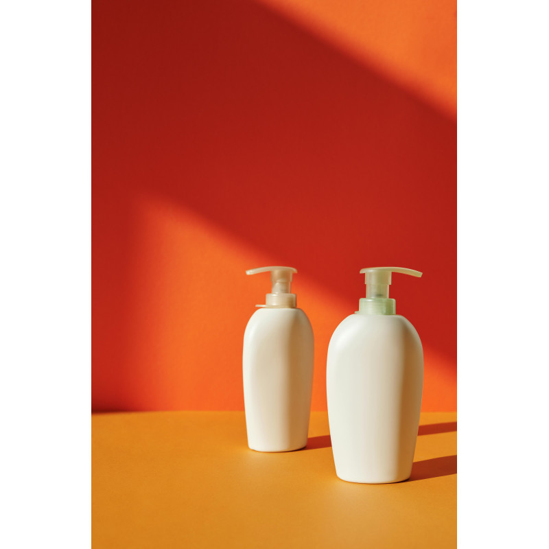 Two White Pump Bottles on Yellow Surface