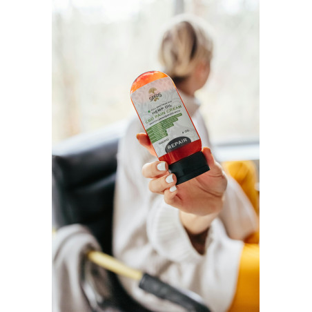 Person Holding Orange Plastic Bottle