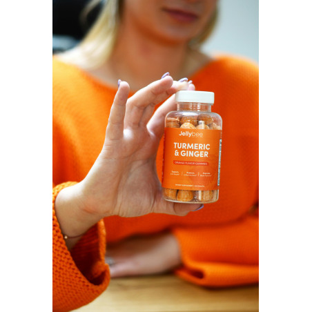 Close-Up Shot of a Person Holding a Bottle of Turmeric and Ginger