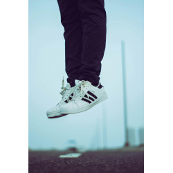 Person Wearing Pair of White Adidas Superstar Shoes