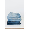 Stack of jeans on white shelf